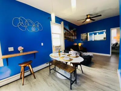 a dining room with blue walls and a table and chairs at NYC Oasis in Mott Haven