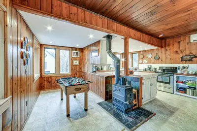 a kitchen with wooden walls and a stove in it at Fly Creek Historic Home By Cooperstown! in Fly Creek