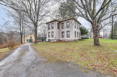 a large white house with a tree and a driveway at Fly Creek Historic Home By Cooperstown! in Fly Creek