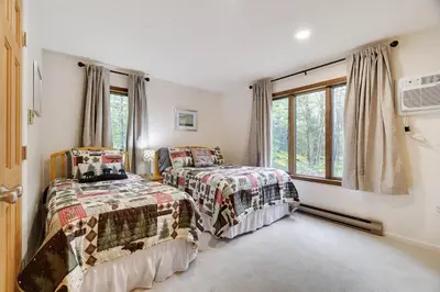 a bedroom with two beds and a window at Lake Front, Hot Tub, Fire Pit, FP, Boats, Ski in Gouldsboro