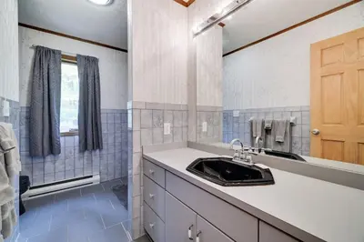 a bathroom with a sink and a mirror at Lake Front, Hot Tub, Fire Pit, FP, Boats, Ski in Gouldsboro