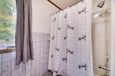 a bathroom with a shower with white tile at Lake Front, Hot Tub, Fire Pit, FP, Boats, Ski in Gouldsboro