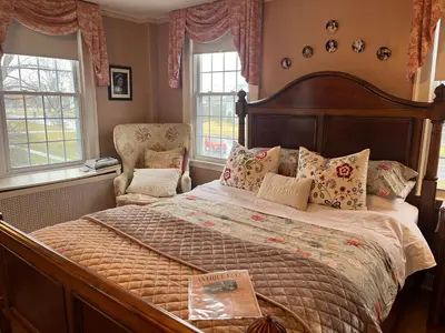 a bedroom with a large bed and two windows at Antique1242 British Bed & Breakfast in Enfield