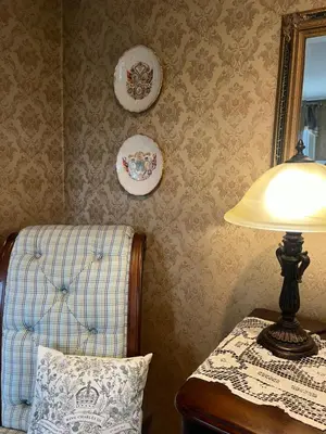 a lamp sitting on a table next to a chair at Antique1242 British Bed & Breakfast in Enfield
