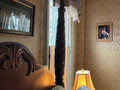 a bedroom with a bed with a lamp and a window at Antique1242 British Bed & Breakfast in Enfield