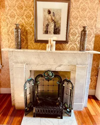a living room with a fireplace with a picture on the wall at Antique1242 British Bed & Breakfast in Enfield
