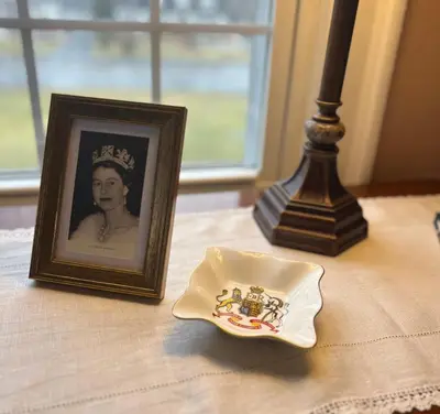 a picture of a queen and a plate on a table at Antique1242 British Bed & Breakfast in Enfield