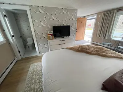 a bedroom with a large white bed and a television at Berkshire Valley Inn in Williamstown