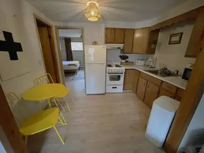 a kitchen with a yellow table and a white refrigerator at Berkshire Valley Inn in Williamstown