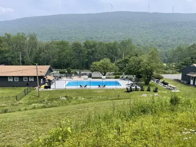 a swimming pool in a field next to a house at Berkshire Valley Inn in Williamstown