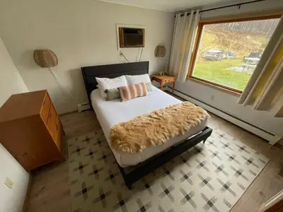a bedroom with a bed and a large window at Berkshire Valley Inn in Williamstown