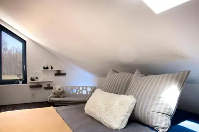 a bedroom with a bed and a couch and a window at WOODSTOCK HISTORIC ARTIST ESTATE - THE MUSEUM HOUSE in Woodstock