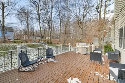 a wooden deck with chairs and a grill on a house at Beach and Lake Access Family Poconos Home with Deck in Tobyhanna