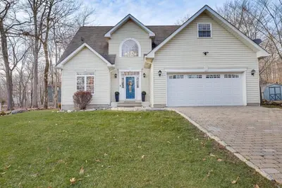 a white house with a white garage at Beach and Lake Access Family Poconos Home with Deck in Tobyhanna