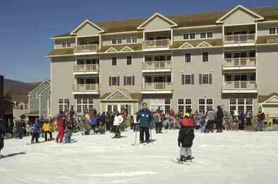 a group of people standing in the snow in front of a large building at Deluxe Mountain Fox Suite Jiminy Peak - Ski On Off - Fully Redone Decor in Hancock
