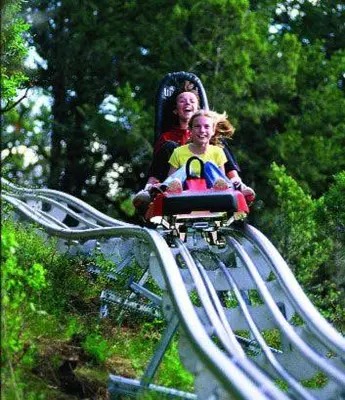 a woman and a child riding on a roller coaster at Deluxe Mountain Fox Suite Jiminy Peak - Ski On Off - Fully Redone Decor in Hancock