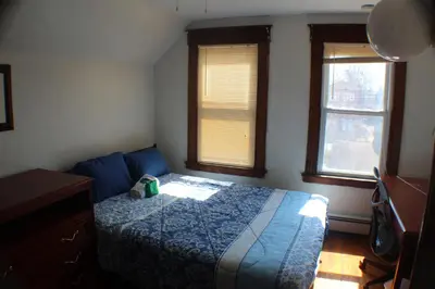 a bedroom with a blue bed and two windows at South End Serenity 2 in Hartford