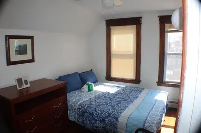 a bedroom with a bed and a dresser and windows at South End Serenity 2 in Hartford