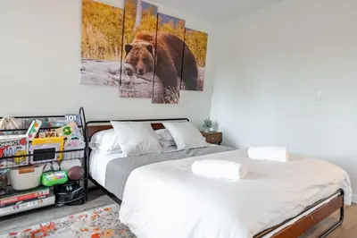 a bedroom with two beds and a brown bear painting at Modern chalet for 8 people with Fireplace, Hot Tub and nearby Skiing in Tobyhanna