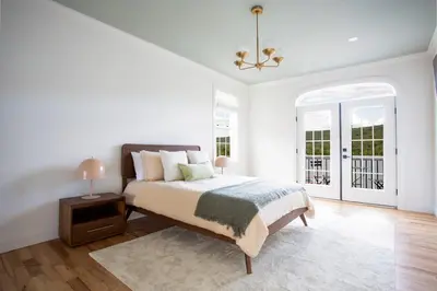 a white bedroom with a bed and a chandelier at Lakeview Villa with Private Hot Tub, Firepit & Spacious Decks with Breathtaking Cliff Views in Greenwood Lake