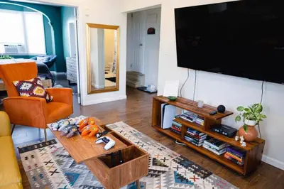 a living room with a flat screen tv on a wall at Rainforest Retreat 20m to NYC FREE Parking - Sleeps 16 in Bayonne