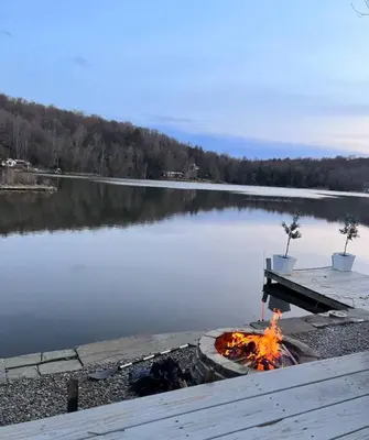 a fire pit next to a body of water at Peaceful place at the lake in Susquehanna
