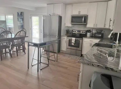 a kitchen with white cabinets and a table with a counter top at Peaceful place at the lake in Susquehanna