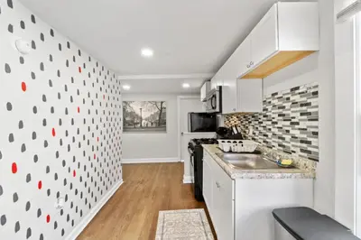 a kitchen with white cabinets and a counter top at Whimsical three in Bayonne