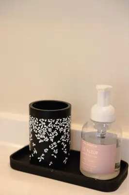 a bottle of soap and a candle on a black tray at Rainforest Retreat 20m to NYC Parking Sleeps 25 in Bayonne