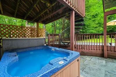 a hot tub on a patio with a gazebo at Luxury Villa with Year Round Heated Pool, Sauna, Spa & Fire Pit - Newly Redone in East Stroudsburg