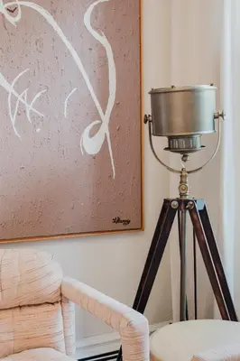 a lamp on a tripod next to a wall with a painting at The West Village Gem in New York