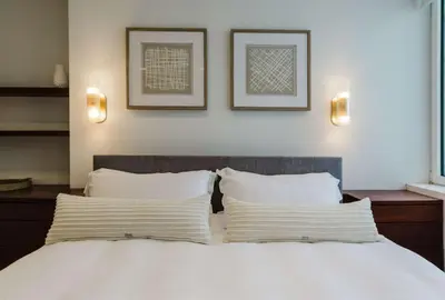 a bedroom with a white bed with two pillows at Private Beautiful Townhome w Zen Garden in New York