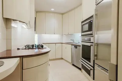 a white kitchen with a stove and a refrigerator at Private Beautiful Townhome w Zen Garden in New York
