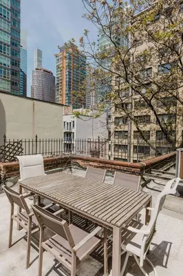 a wooden table and chairs on the roof of a building at Private Penthouse w Roof Oasis in New York
