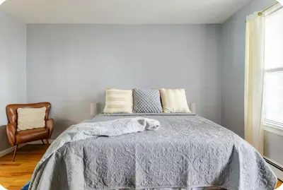 a bedroom with a bed with a blanket and a chair at K-Marie Estate in Mount Vernon