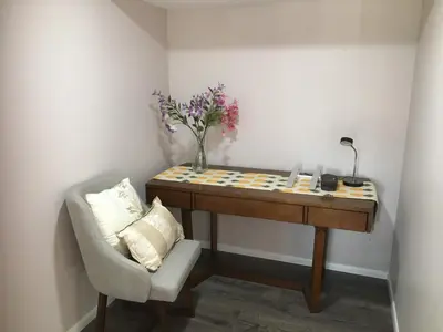 a desk with a chair and a vase with flowers on it at Privacy, entertainment, comfort galore 2 BR LR 1BA Home Theater, Pool Table in Suffield
