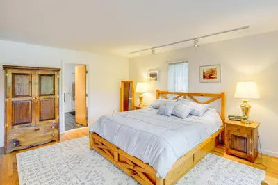 a bedroom with a large bed with a wooden frame at Great Barrington Lakeside Getaway with Kayak and Grill in Great Barrington