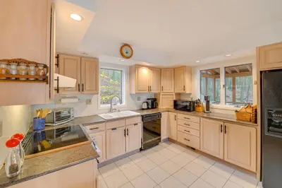 a kitchen with wooden cabinets and a clock on the ceiling at Great Barrington Lakeside Getaway with Kayak and Grill in Great Barrington