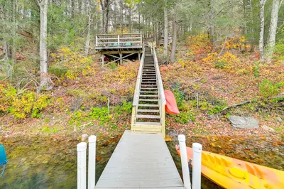 a wooden stairs leading to a bridge over a river at Great Barrington Lakeside Getaway with Kayak and Grill in Great Barrington