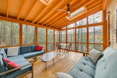 a living room with blue couches and a table at Great Barrington Lakeside Getaway with Kayak and Grill in Great Barrington