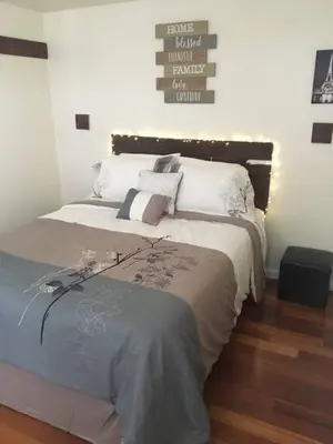 a bedroom with a large bed with white and gray sheets at Meet the browns with parking in Schenectady