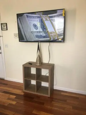 a tv hanging on a wall with a small table at Meet the browns with parking in Schenectady