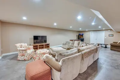 a living room with couches and a flat screen tv at Monterey Home with Hot Tub, Pool and Game Room! in Monterey