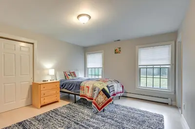 a bedroom with a bed and a dresser and windows at Monterey Home with Hot Tub, Pool and Game Room! in Monterey