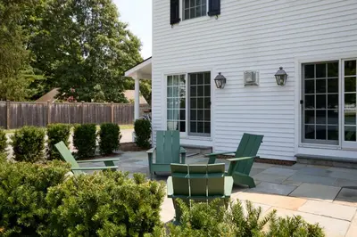 a patio with chairs and tables in front of a house at The Kent Collection - The Firefly Inn in Kent