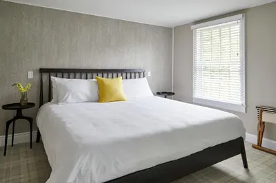 a bedroom with a large white bed with yellow pillows at The Kent Collection - The Firefly Inn in Kent