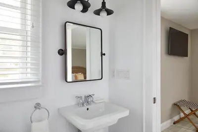 a white bathroom with a sink and a mirror at The Kent Collection - The Firefly Inn in Kent