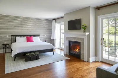 a bedroom with a bed and a fireplace at The Kent Collection - The Firefly Inn in Kent