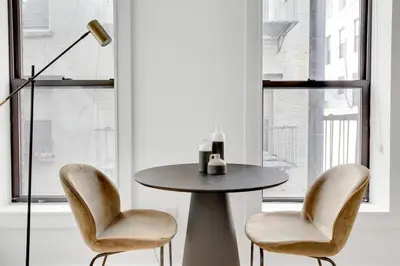 a table in a room with two chairs and a lamp at Little Italy 1br w wd nr SoHo NYC-756 in New York