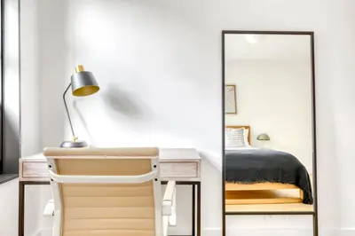 a bedroom with a mirror and a desk with a lamp at BK Heights 2BR w WD Elevator nr Promenade NYC-910 in Brooklyn